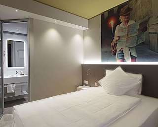 Interno di una camera d&#039;albergo con bagno visibile.